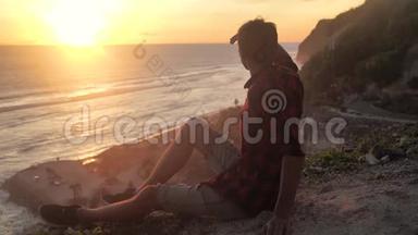 人类旅行者坐在岩石上，<strong>欣赏</strong>日落的海景。 徒步旅行者坐在大石头上，放松并<strong>欣赏风景</strong>